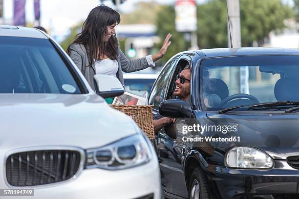 woman on bicycle talking to man in car - car transmission stock-fotos und bilder