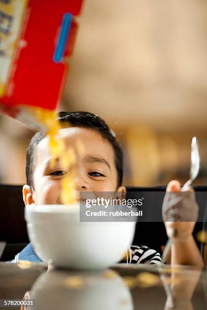 boy with bowl of cereal and spoon smiling - cereal box stockfoto's en -beelden