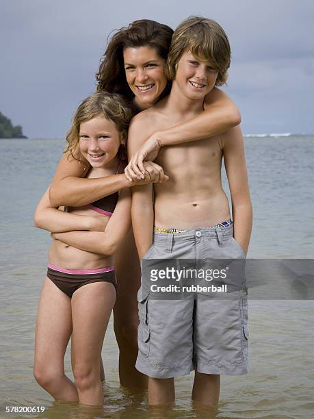 portrait of a mother embracing her two children - preteen girl no shirt stock pictures, royalty-free photos & images