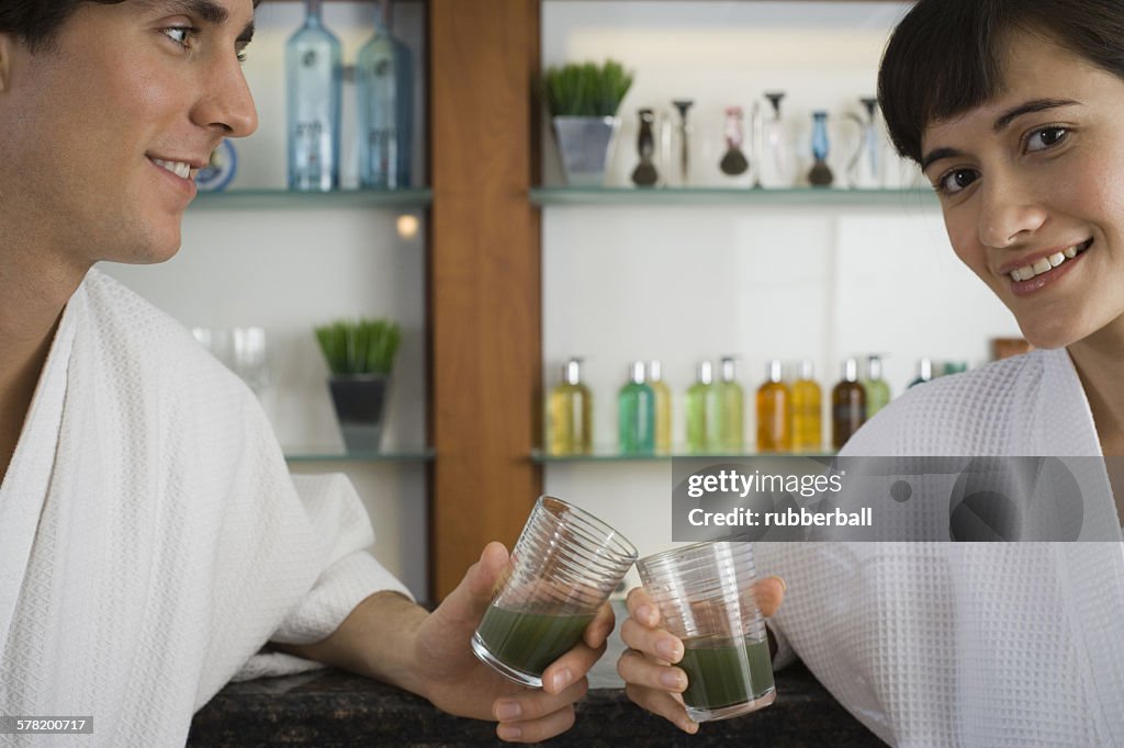 Portrait of a young couple holding glasses of wheatgrass juice