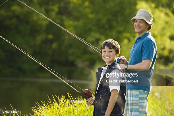 man and his son fishing - tee reel stock pictures, royalty-free photos & images