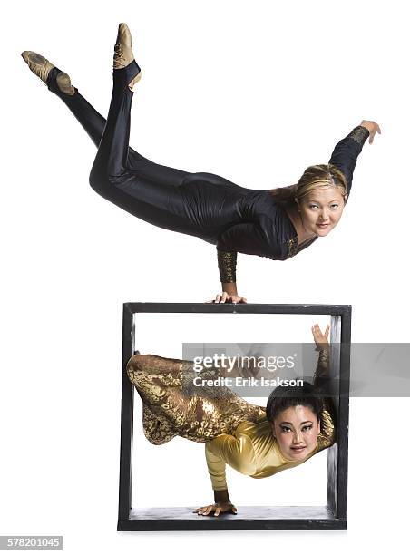 female contortionist duo with box prop - young contortionist stockfoto's en -beelden