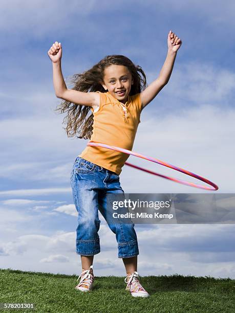 girl playing with hula hoop outdoors - hooping stock pictures, royalty-free photos & images