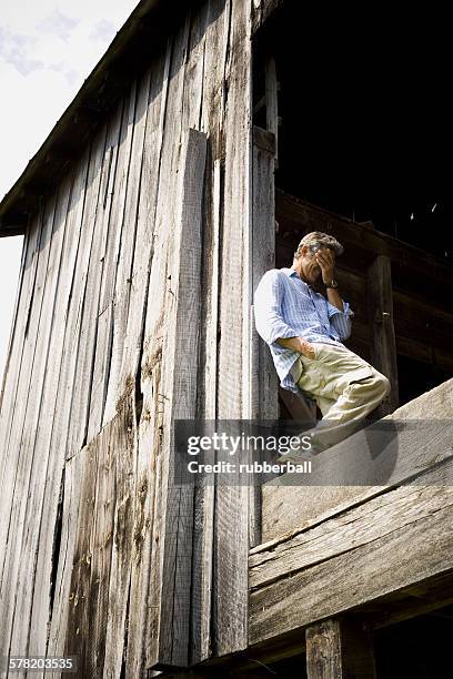 low angle view of a man leaning against a wooden wall - rayado photos et images de collection