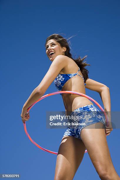 young woman playing with a hula hoop - vitalidad stock pictures, royalty-free photos & images