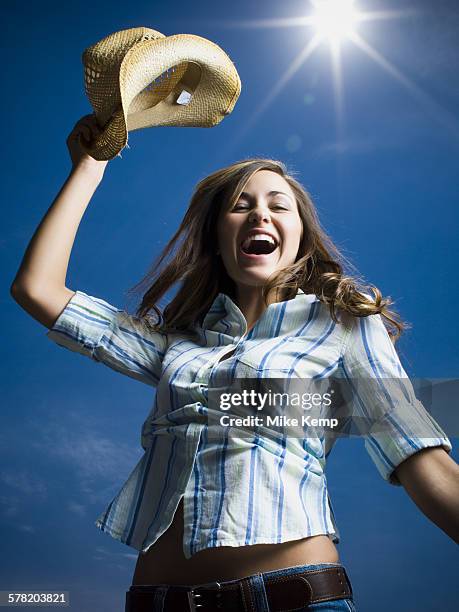 low angle view of a young woman with her arms raised - vitalidad stock pictures, royalty-free photos & images