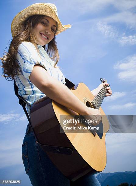 low angle view of a young woman playing the guitar - rayado photos et images de collection