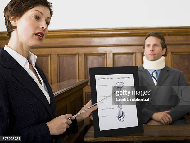 a female lawyer pointing at evidence in front of a victim in a courtroom - prosecutor bildbanksfoton och bilder