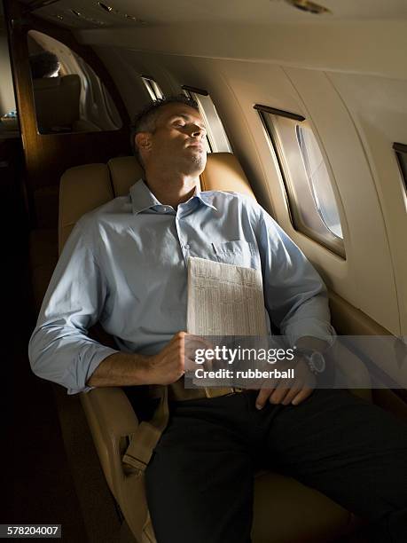 a businessman sleeping in an airplane - business class reclining plane stock pictures, royalty-free photos & images