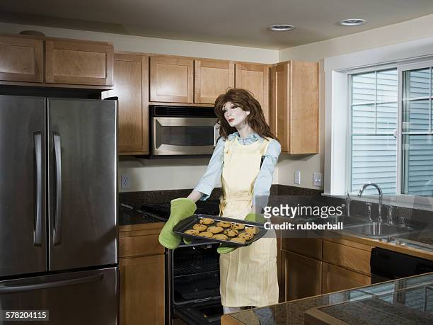 mannequin portraying a woman holding a tray of biscuits - futurista stock pictures, royalty-free photos & images