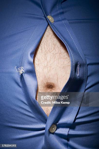close-up of fat stomach bursting through shirt - male belly button stock pictures, royalty-free photos & images