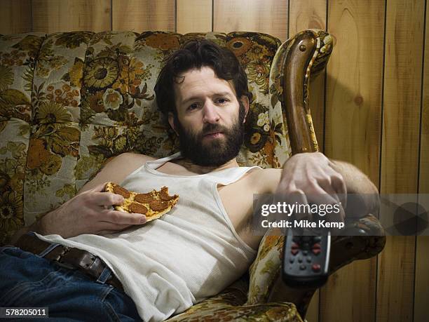 man on sofa with pizza and remote - sloth stock pictures, royalty-free photos & images