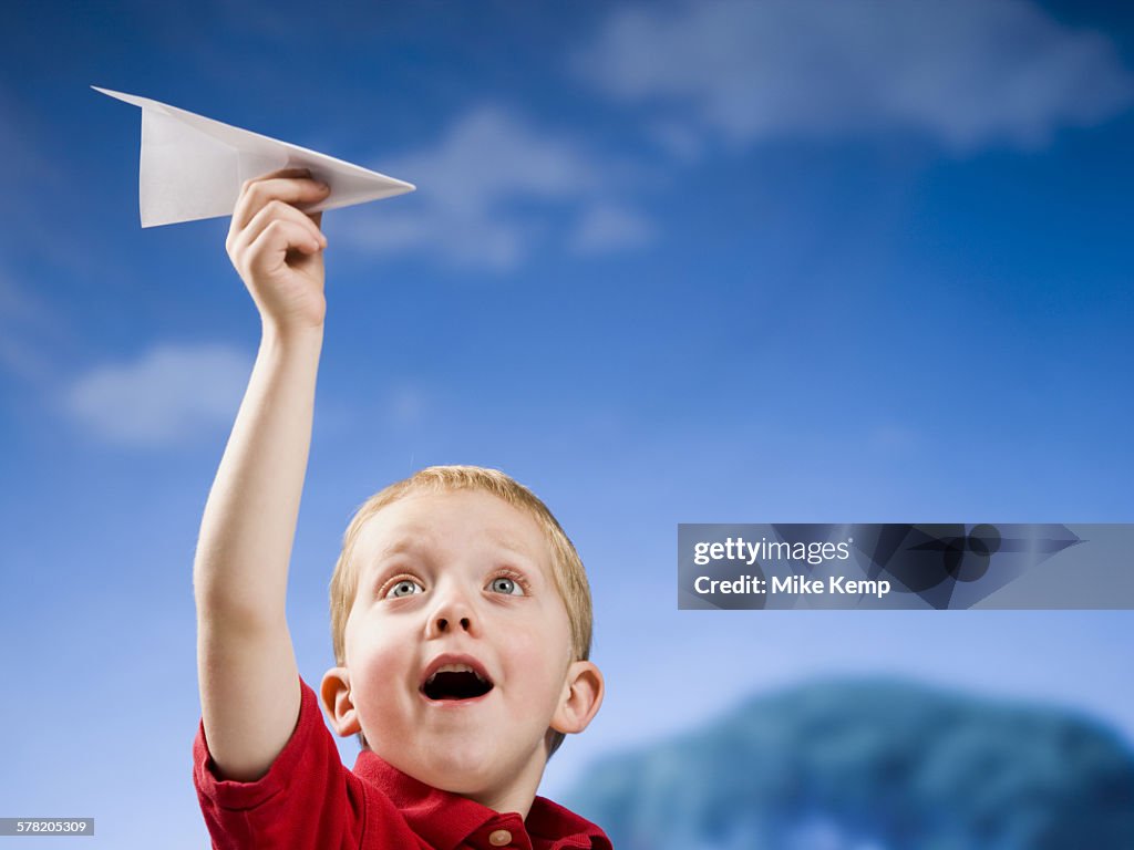 Boy with paper airplane outdoors