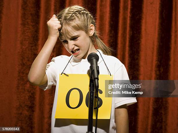 girl contestant standing at microphone thinking - spelling bee stock pictures, royalty-free photos & images