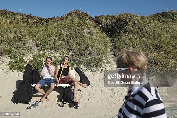 Street musicians play along the boardwalk next to a dune on a beach on Sylt Island on July 19, 2016 near Wenningstedt, Germany. Sylt Island, with its...
