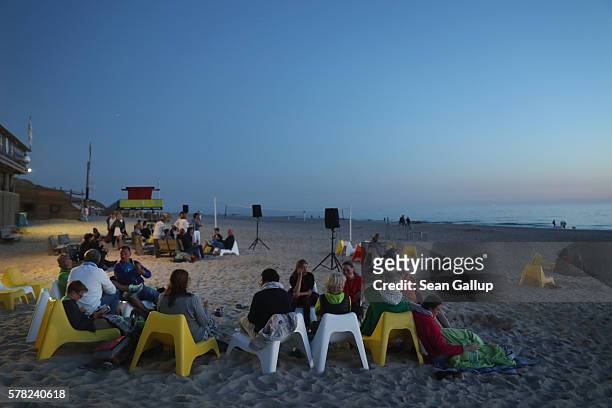 Visitors relax at an outdoor cafe at a beach after sunset on Sylt Island on July 19, 2016 near Wenningstedt, Germany. Sylt Island, with its long...