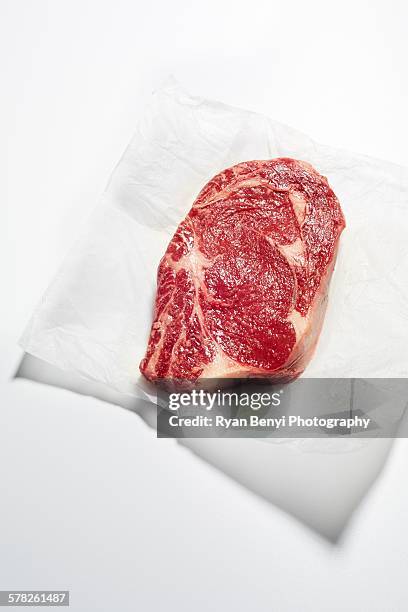 still life of raw rib-eye steak on greaseproof paper - wax paper fotografías e imágenes de stock