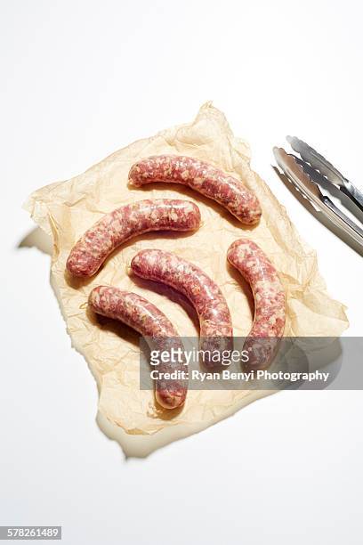 still life of raw italian sausages on brown paper - viande fond blanc photos et images de collection