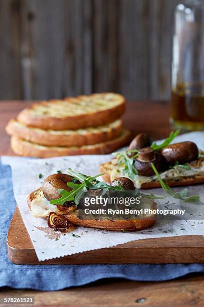 still life of bruschetta with portobello mushroom roasted cipollini onion, gouda cheese and fresh arugula - bruschetta stock-fotos und bilder