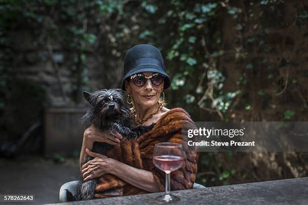 fashionable senior woman with dog in garden - glamorous woman stock-fotos und bilder