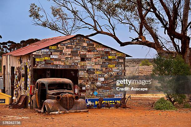 An old garage wall decorated with number plates in a ghost town, Gwalia was a gold-mining town, Underground mining began in 1897 at the Sons of...