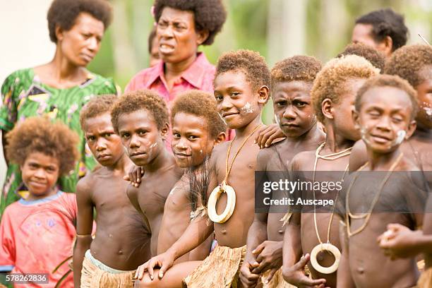 Village children and three women. The children's yellowed hair is from constant dipping in the sea, it returns to when they grow up. Matong village,...