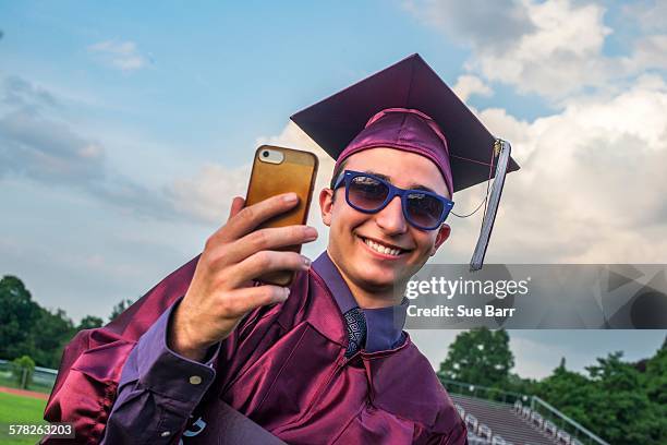 graduate taking selfie with smartphone - purple hat stock pictures, royalty-free photos & images