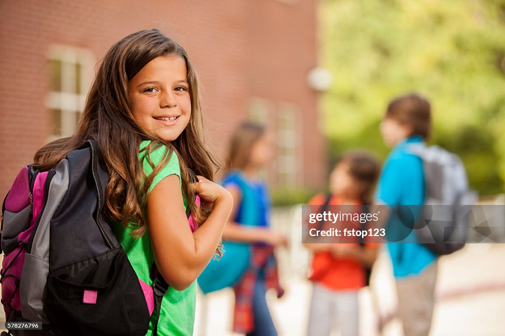 De volta à escola: crianças em idade primária, menina no campus da escola.