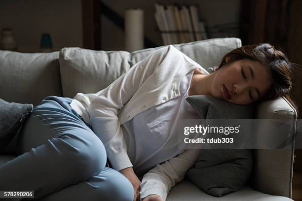 müde hausfrau schlafen auf dem sofa - homemaker stock-fotos und bilder