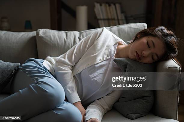 tired housewife sleeping on the sofa - asian sleeping stock pictures, royalty-free photos & images