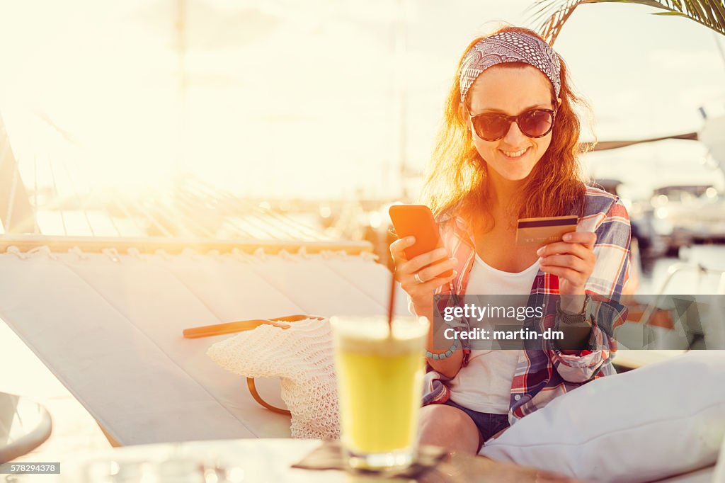 Mujer que usa tarjeta de crédito en unas vacaciones
