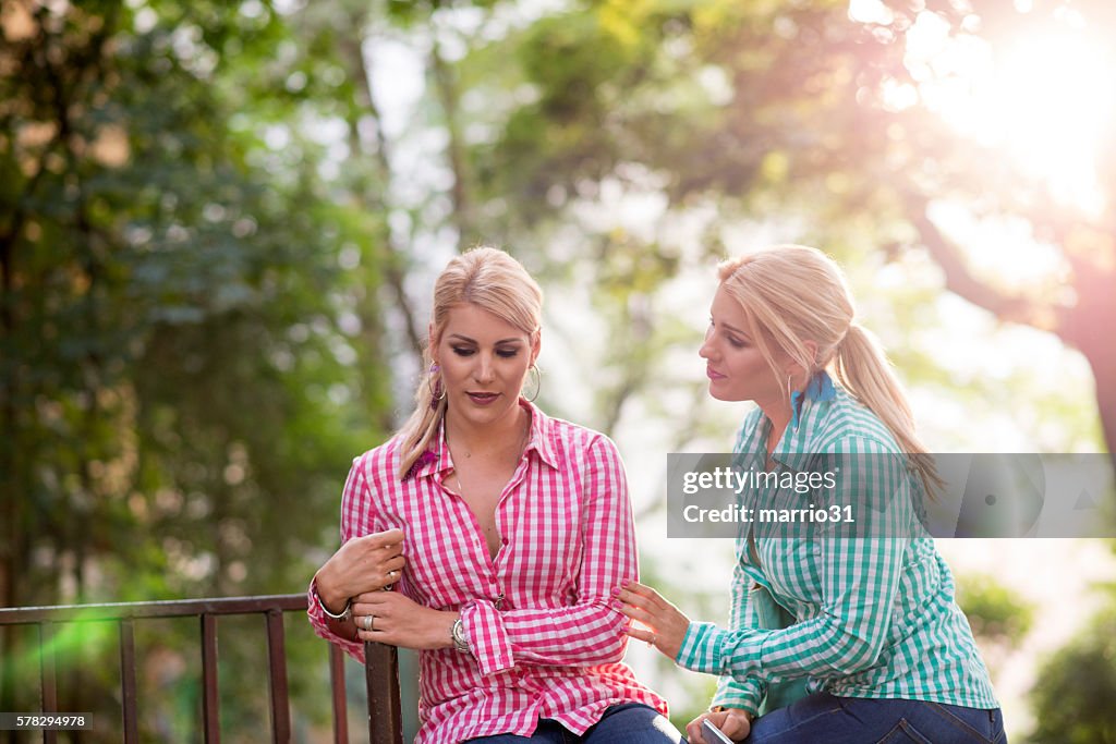 Two sad young beautiful girls portrait outdoors