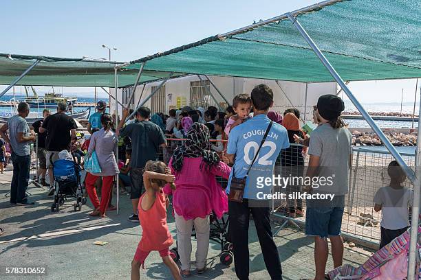 volunteers are distributing children's clothing in refugee camp - quiosque stock pictures, royalty-free photos & images