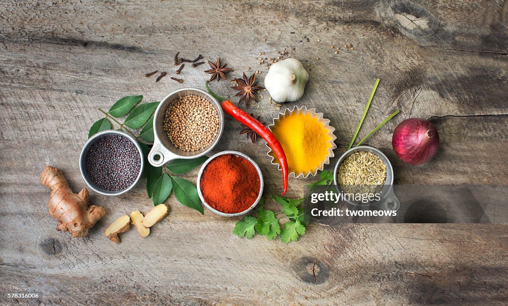 Flat lay overhead view herb and spices on rustic wooden background.