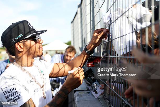 Lewis Hamilton of Great Britain and Mercedes GP signs autographs for fans during previews ahead of the Formula One Grand Prix of Hungary at...