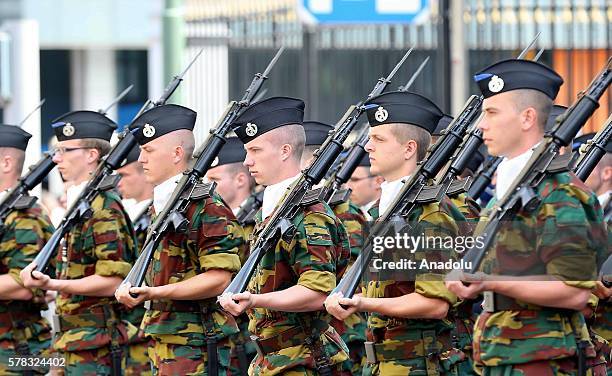 Soldiers are seen as King Philippe of Belgium salutes the crowd during the parade organized within the ceremonies marking Belgium's National Day on...