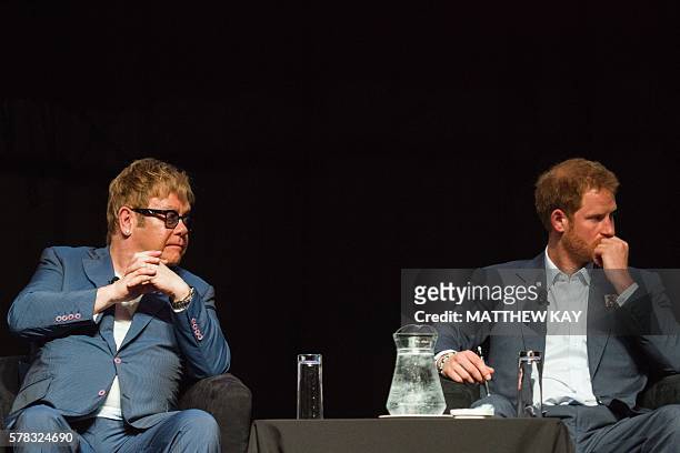 British singer Elton John and Britain's Prince Harry attend the International Aids Conference at the international convention centre in Durban on...
