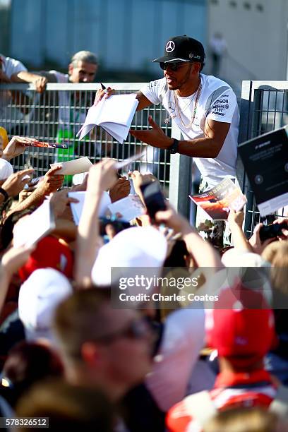 Lewis Hamilton of Great Britain and Mercedes GP signs autographs fos fans during previews ahead of the Formula One Grand Prix of Hungary at...