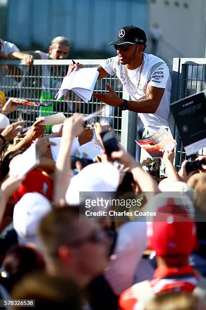 Lewis Hamilton of Great Britain and Mercedes GP signs autographs fos fans during previews ahead of the Formula One Grand Prix of Hungary at...