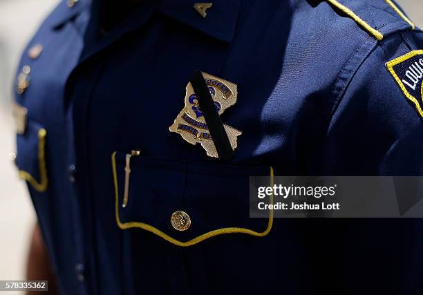 Black band is displayed around Louisiana State Police Officer Bryan Lee badge during a prayer vigil for Baton Rouge Police Officers Montrell Jackson,...