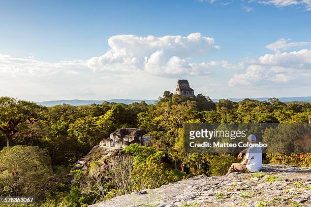 man looking at temples in the forest, guatemala - maya guatemala stock pictures, royalty-free photos & images