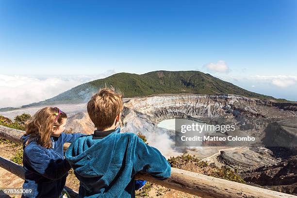 Two children looking in the crater of Poas volcano