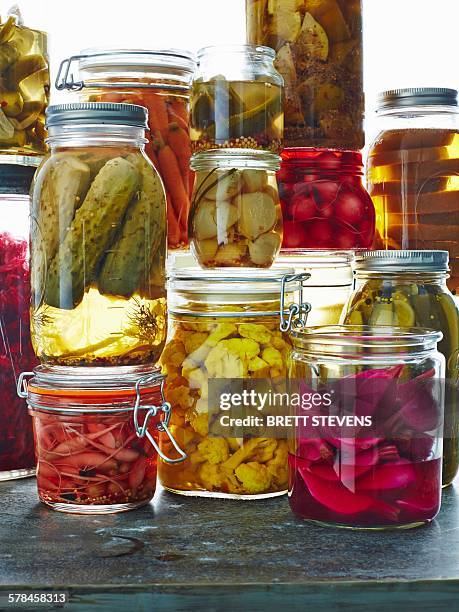 various pickles in glass jars, close-up - salmuera fotografías e imágenes de stock