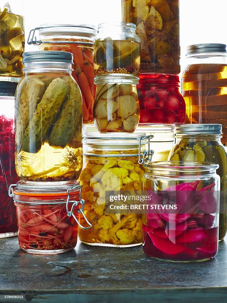 Various pickles in glass jars, close-up