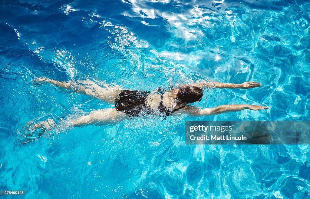 Overhead view of mature woman swimming in swimming pool