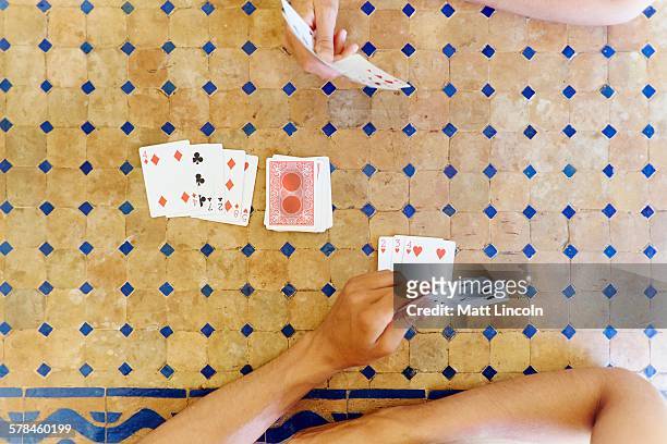 overhead cropped shot of mature woman and son playing cards at table - hand of cards stock-fotos und bilder