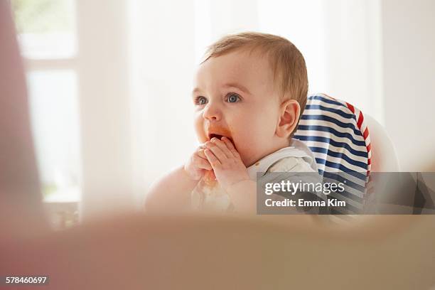 baby boy feeding himself in baby chair - adult eating no face stock pictures, royalty-free photos & images