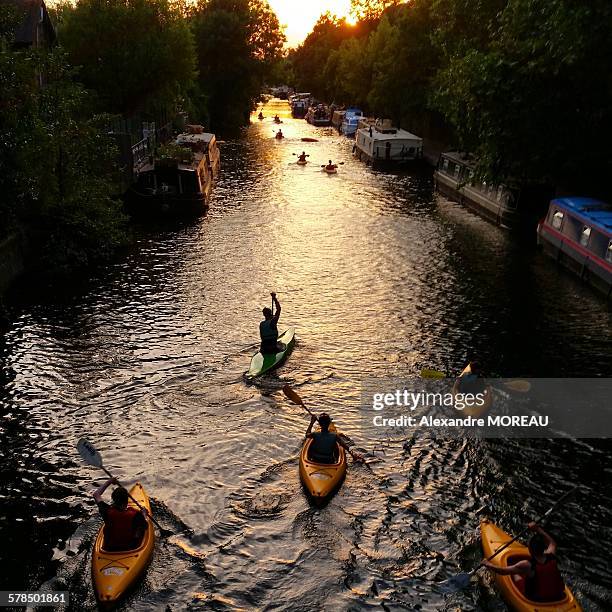 people canoeing on regent's canal at dusk - east london london stock-fotos und bilder