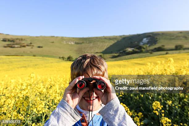 smiling boy using binoculars - wilmington - east sussex imagens e fotografias de stock