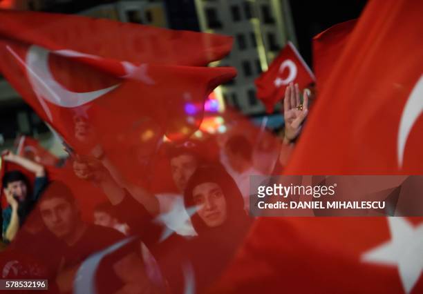 Erdogan supporters wave Turkish flags as they gather at Taksim square on July 21, 2016 during a rally in Istanbul, following the failed military coup...